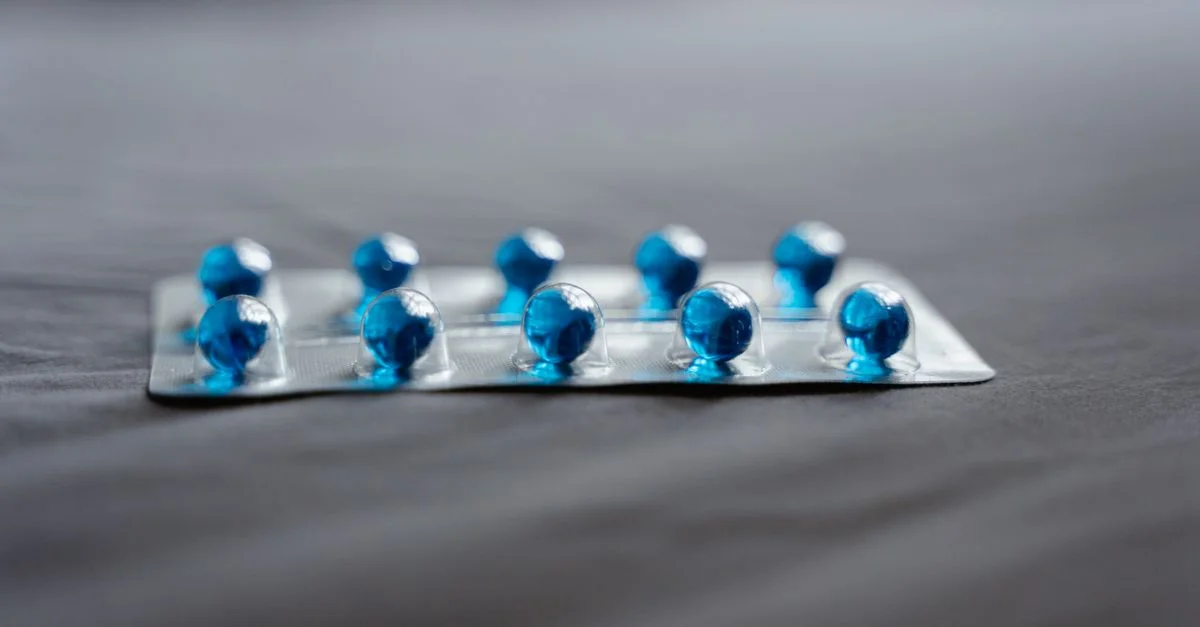 Imagen detallada de pastillas azules en un blister sobre una superficie suave.
